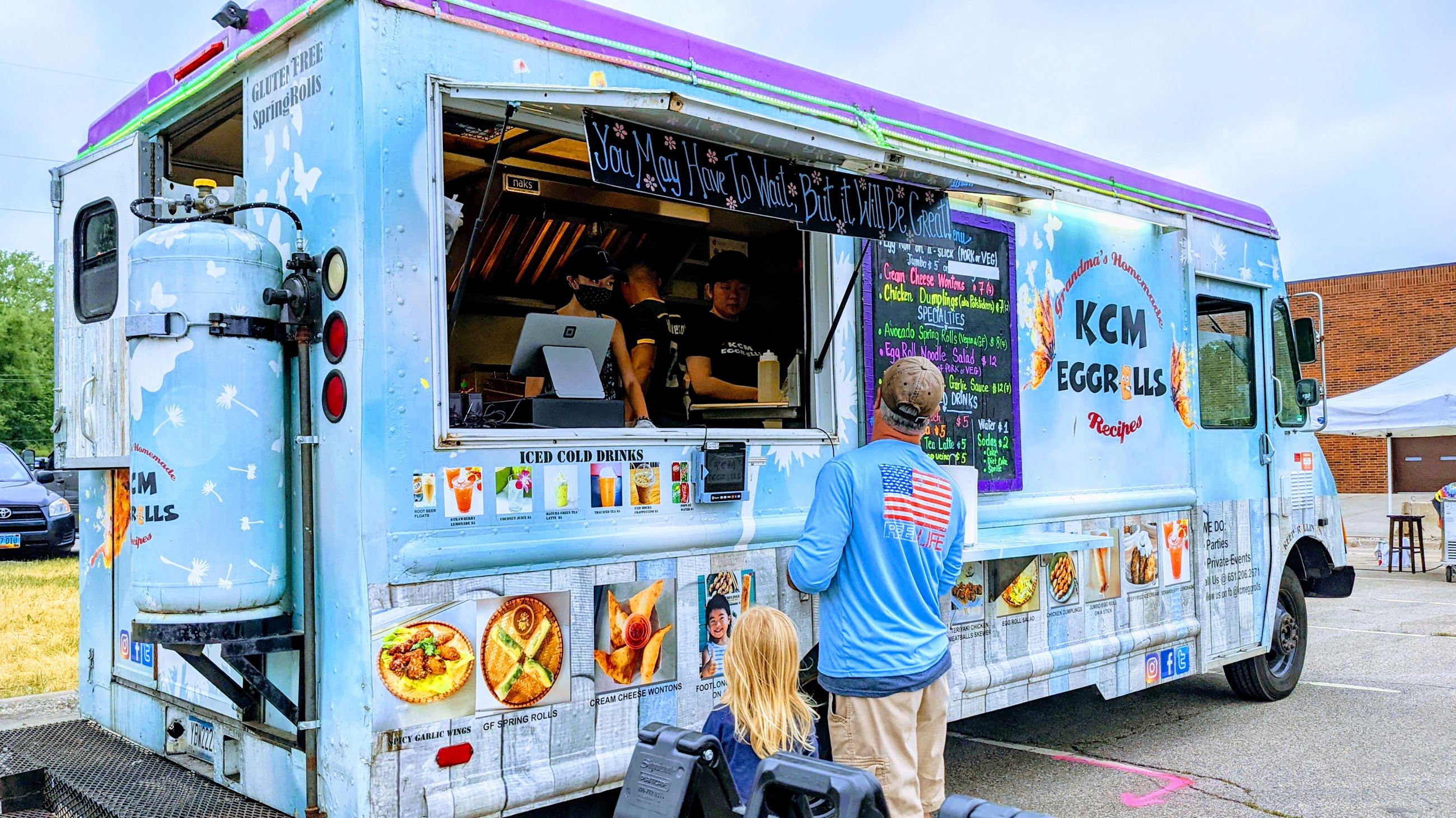 Customers look at food truck menu