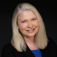 Headshot of Lori Pulkrabek on black background